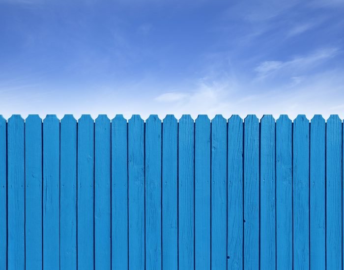 Simple wooden slat fence with parallel planks stained with royal Fence wooden parallel bars, painted blue. Isolated on a white background. With clipping path.
